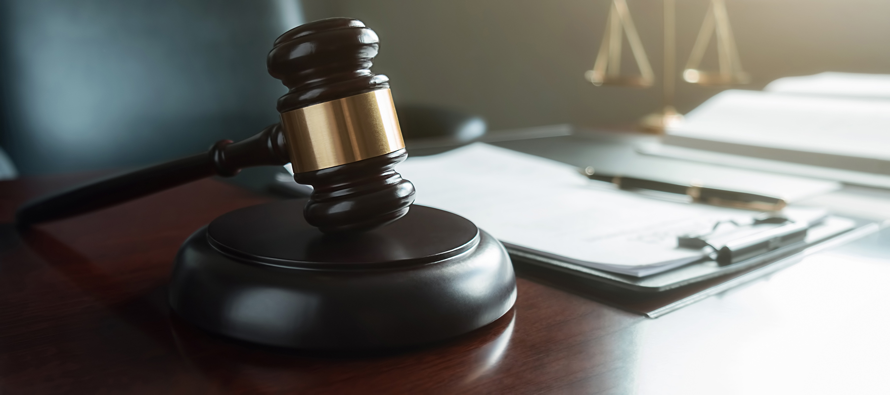 Wooden gavel on a stack of legal papers, symbolizing law and justice